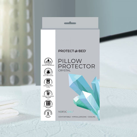 A package of Protect-A-Bed Crystal Cooling Pillow Protector With Tencel on a bed.