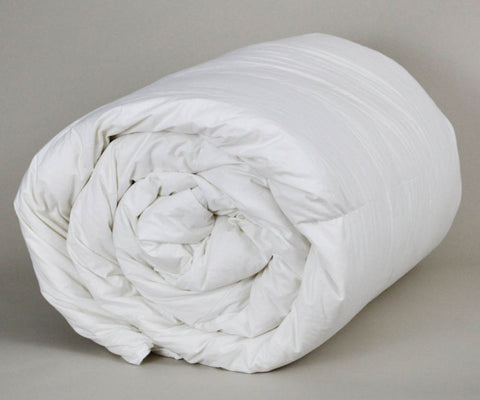 A rolled up Down Etc. Aquaplush Comforter in cotton fabric on a grey background.