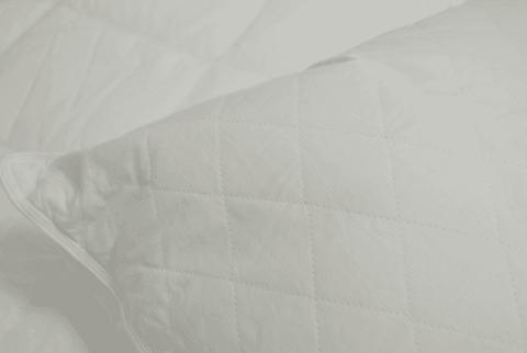 This close-up photo features a white quilted pillow with Down Etc. Diamond Support.