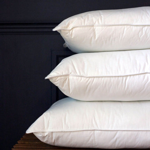 Three Down Etc. Fairfax Firm Polyester Pillows stacked on top of each other, perfect for side sleepers.