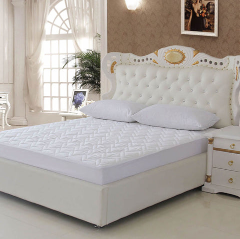A white Down Etc. Lily Pad Mattress Pad with a softness headboard.