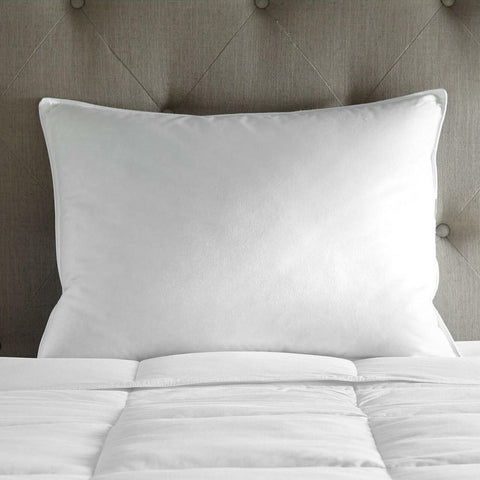 A Cloud Nine Comforts Hotel Pillow on top of a bed.