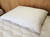 A Holy Lamb Organics Wooly Down Bed Pillow made with breathable wool on a wooden bed.