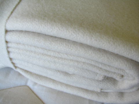 A white blanket made with Holy Lamb Organics Wool Moisture Barriers, perfect for your bed.
