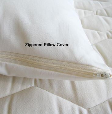 A Holy Lamb Organics zippered pillow protector made of organic cotton on a bed.