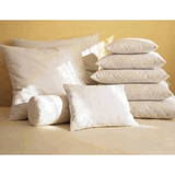 Homespun pillows by Keeco on a bed add a decorative touch to the room.