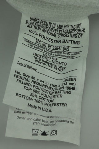 A piece of paper with a Restful Nights Extra Ordinaire Mattress Pad label attached to it.
