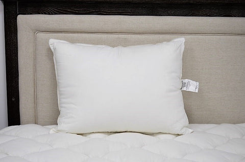 A white JS Fiber "Ultra Down" Polyester Pillow | Soft sitting on a bed.