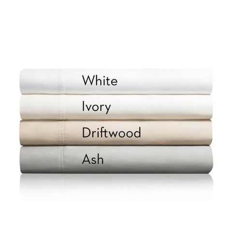 A stack of Malouf 600 TC Cotton Blend Pillowcase Sets in white, ivory, driftwood, and ash colors.