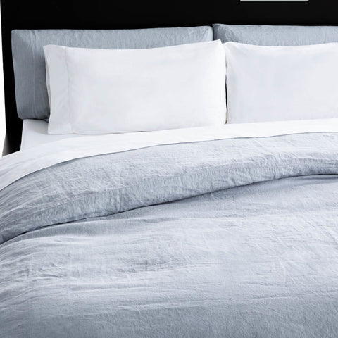 A bed with a Malouf French Linen Duvet Set made of French linen.
