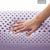 A hand is holding a Malouf Zoned Dough Lavender Pillow with holes in it, filled with memory foam for extra comfort.