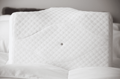 A white Opulence Cervical Memory Foam Pillow lies on the bed.