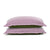 Two stacked pillows with light purple PureCare Cooling Bamboo pillow shams on a white background, the upper one resting slightly askew on the lower green pillow.