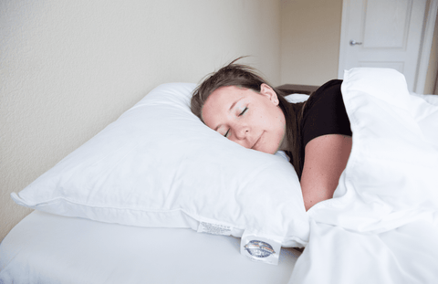 A woman sleeping peacefully on a Pacific Coast Feather Company Double Touch of Down Pillow.