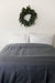 A bed with a Pillowtex Cotton Duvet Cover for Weighted Blanket and a wreath on the wall.