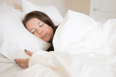 A woman sleeping in a bed covered with a Pillowtex Duvet Cover | Wrinkle Resistant Cotton Blend®.