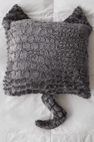 A Pillowtex plush pillow with a crocodile head on it.