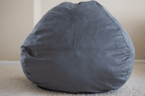 A gray Pillowtex bean bag resting on the floor, plush cover.