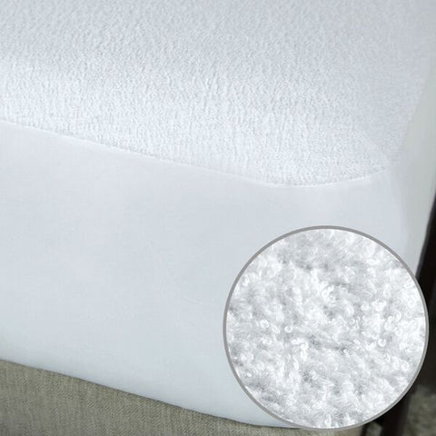 A Protect-A-Bed waterproof mattress protector with a white circle on it, made of cotton terry fabric.