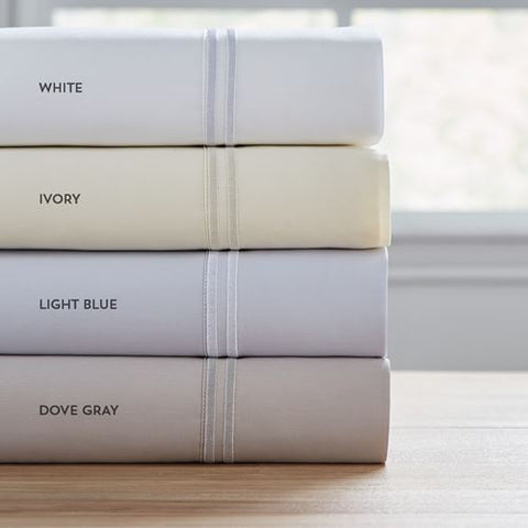 A luxury stack of PureCare Premium Soft Touch TENCEL™ Modal Sheet Sets with different colors on top.