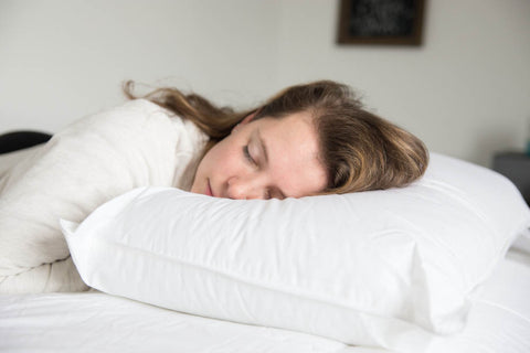 A woman peacefully sleeping on a Hollander Holiday Inn® Polyester Pillow for firm support.