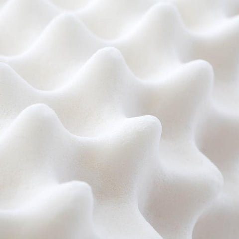 A close up of a Malouf Convoluted Contour Latex foam mattress designed for support.