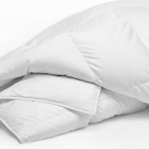 A Temperloft Down/Down Alternative Comforter from Sysco Guest Supply, filled with natural down clusters, providing excellent temperature control, resting on a white surface.